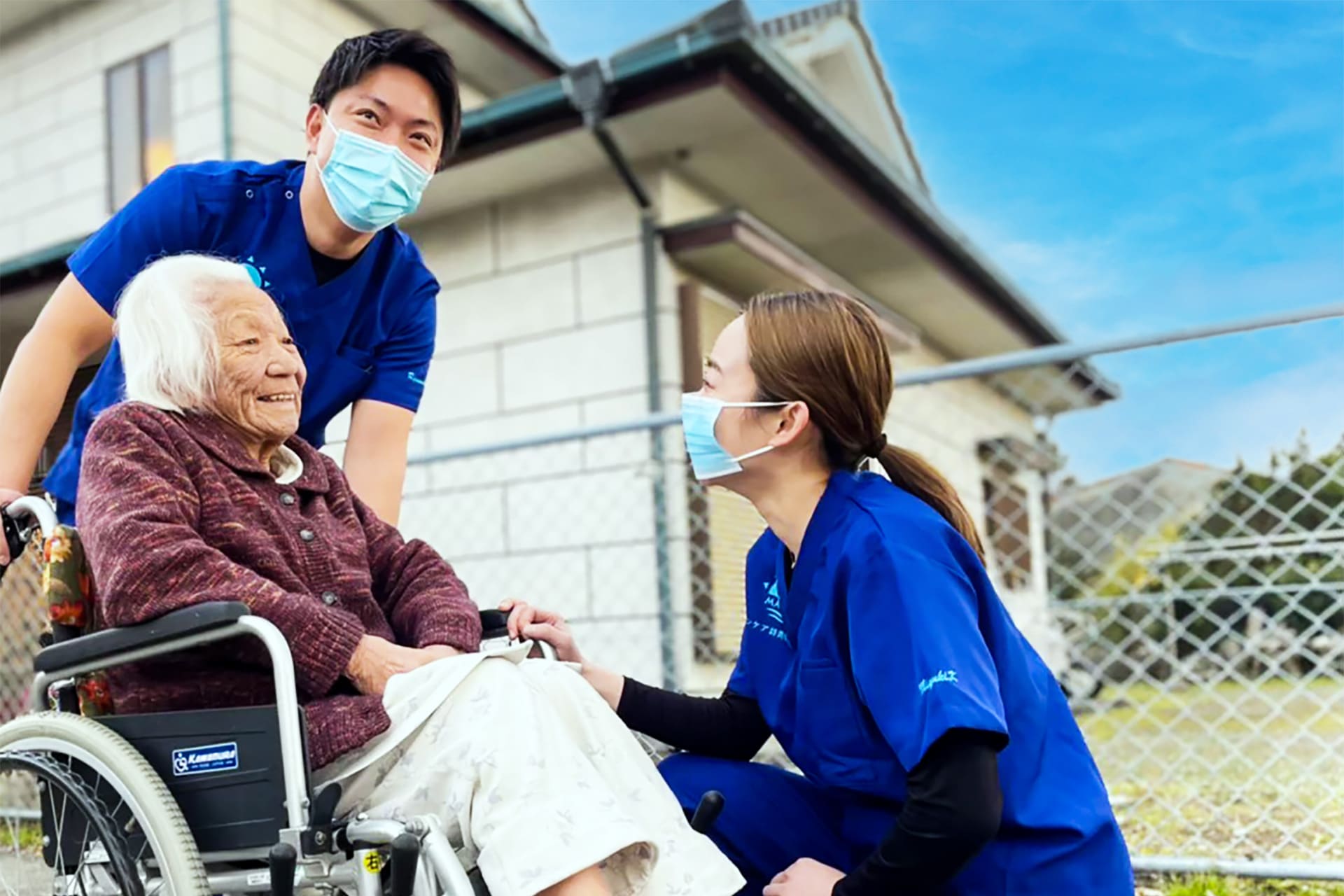 看護師が高齢者の車いすを押している様子