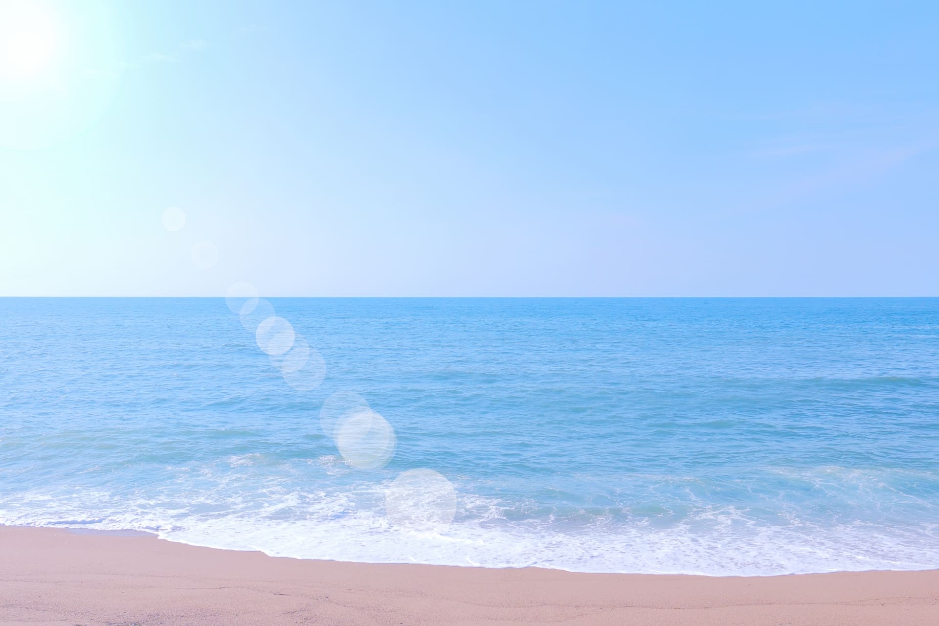 マリンケア訪問看護ステーションのイメージ。砂浜に波が打ち寄せ、太陽がまぶしく輝いている。